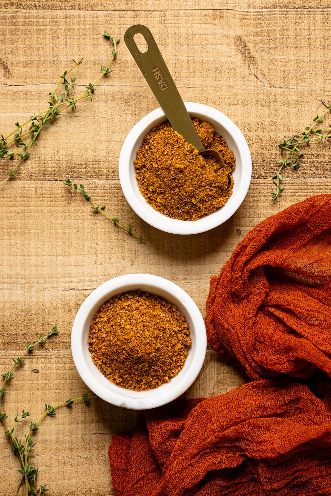 Cajun seasoning recipe ingredients in two white bowls with a spoon.