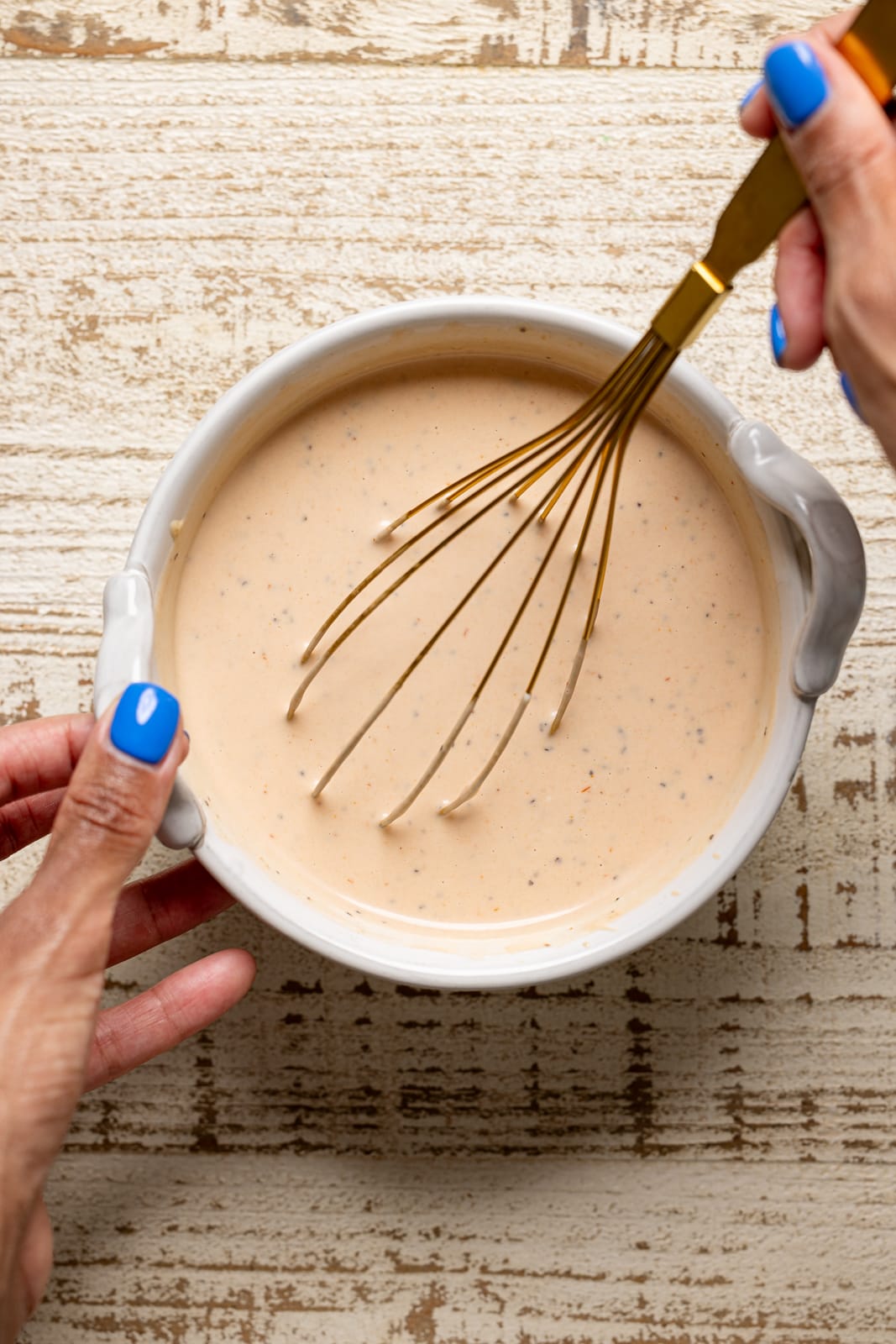 Whisking In-N-Out Burger Sauce ingredients together in a white bowl.