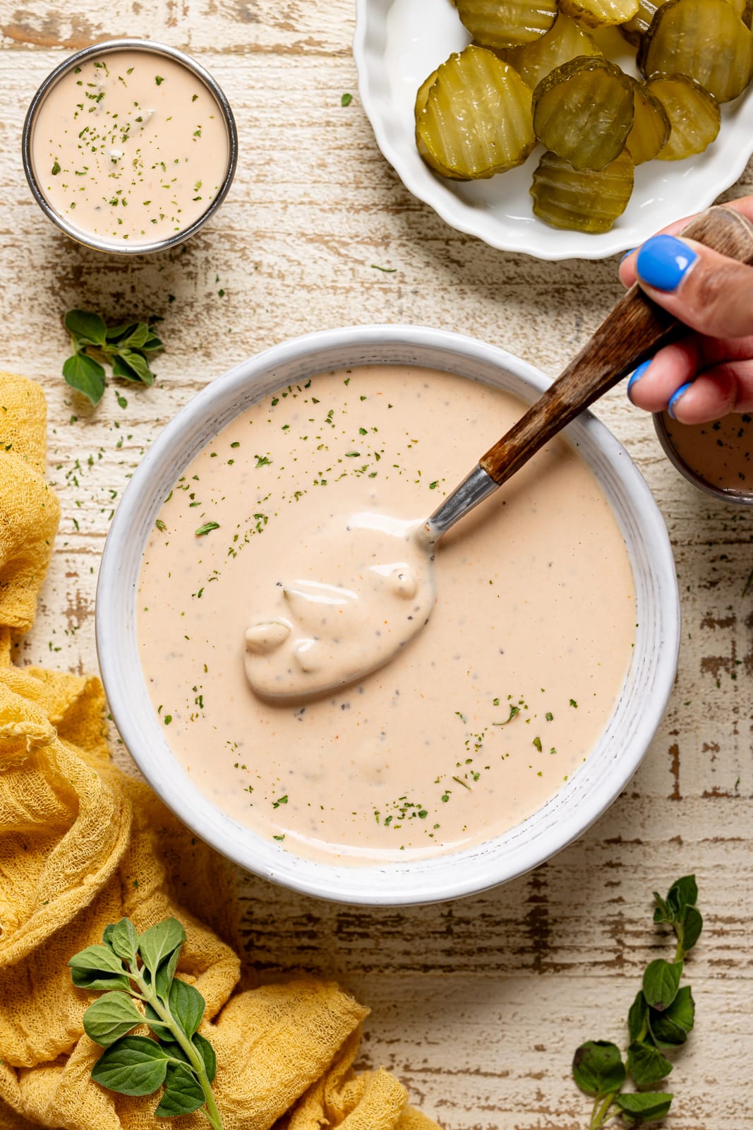 Sauce in a white bowl with a spoon being held. 