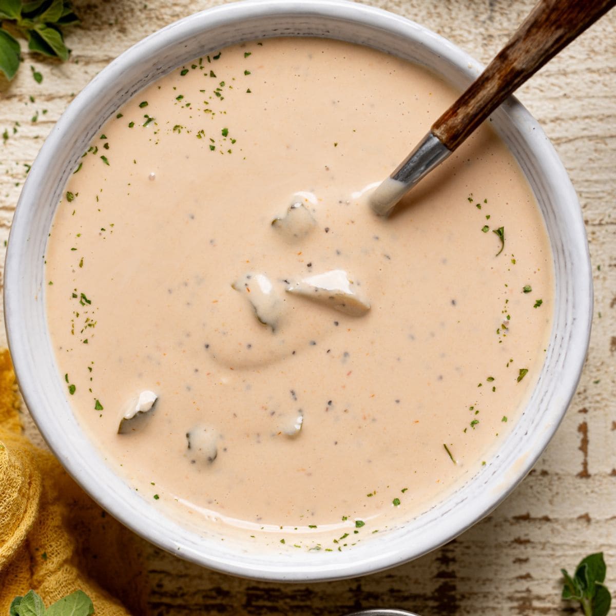 Up close shot of sauce in a white bowl with spoon.