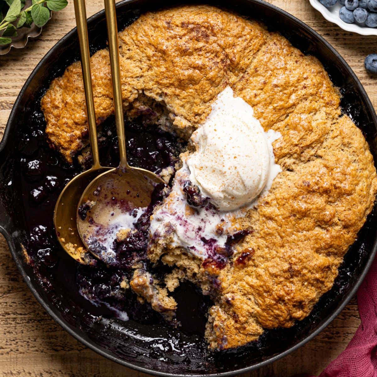 Cobbler scooped out with ice cream and two spoons.