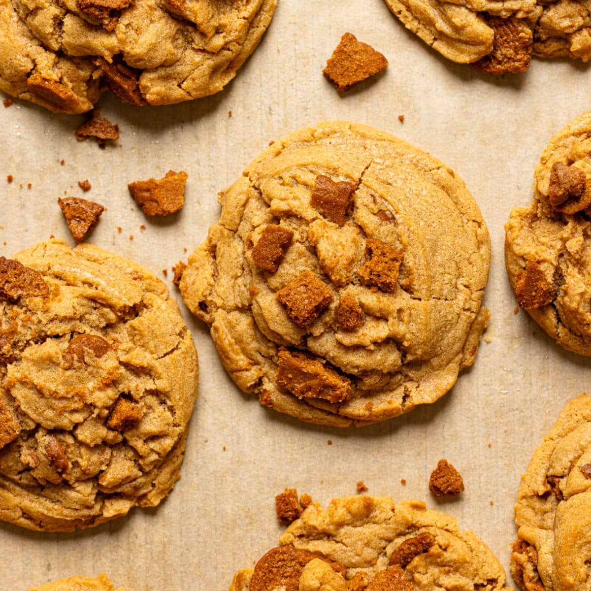 Up close shot of baked cookies on baking sheet with parchment paper.