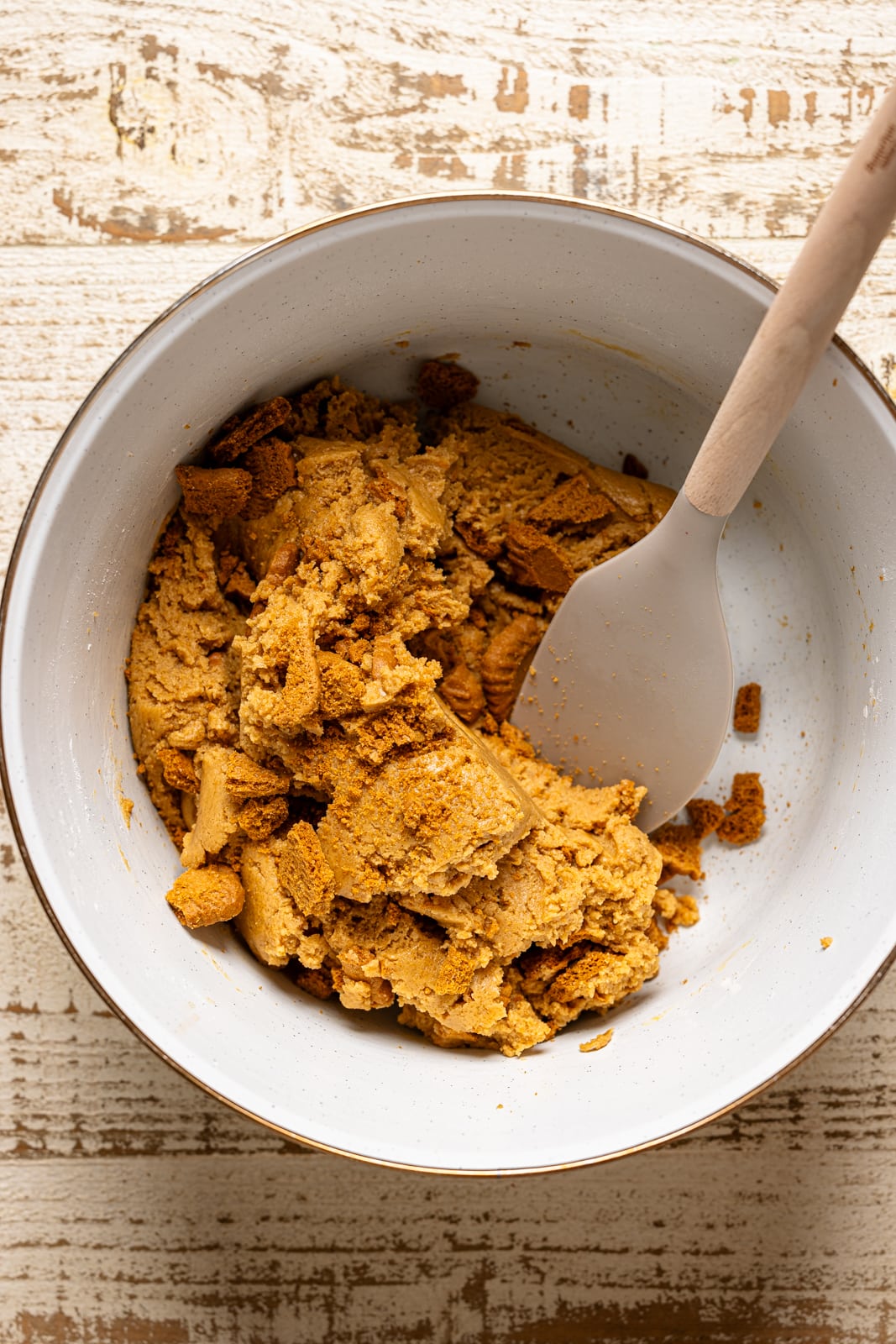 Cookie batter in a white bowl with a spatula. 