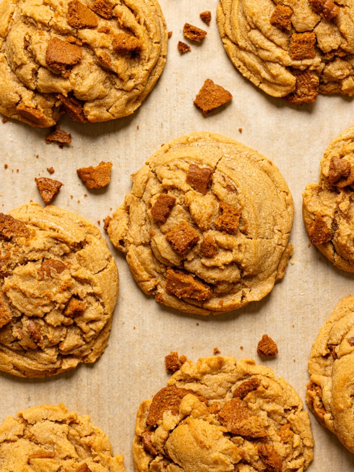 Up close shot of baked cookies on baking sheet with parchment paper.