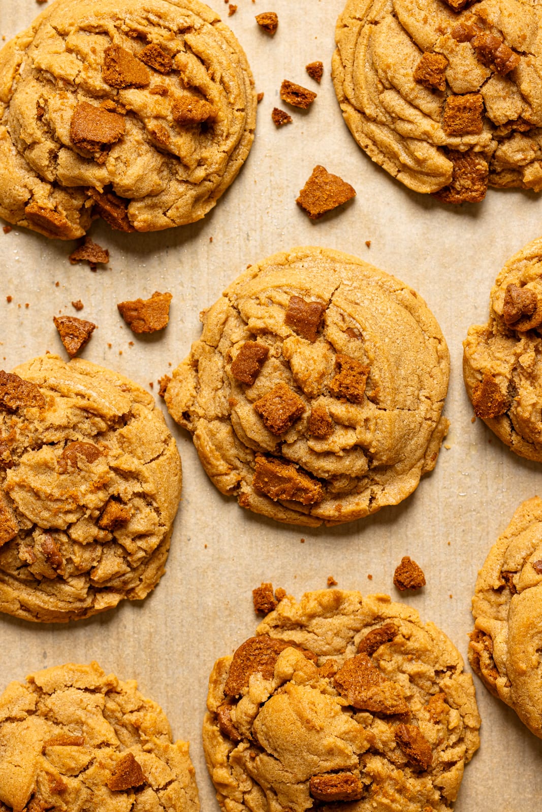 Up close shot of baked cookies on baking sheet with parchment paper.