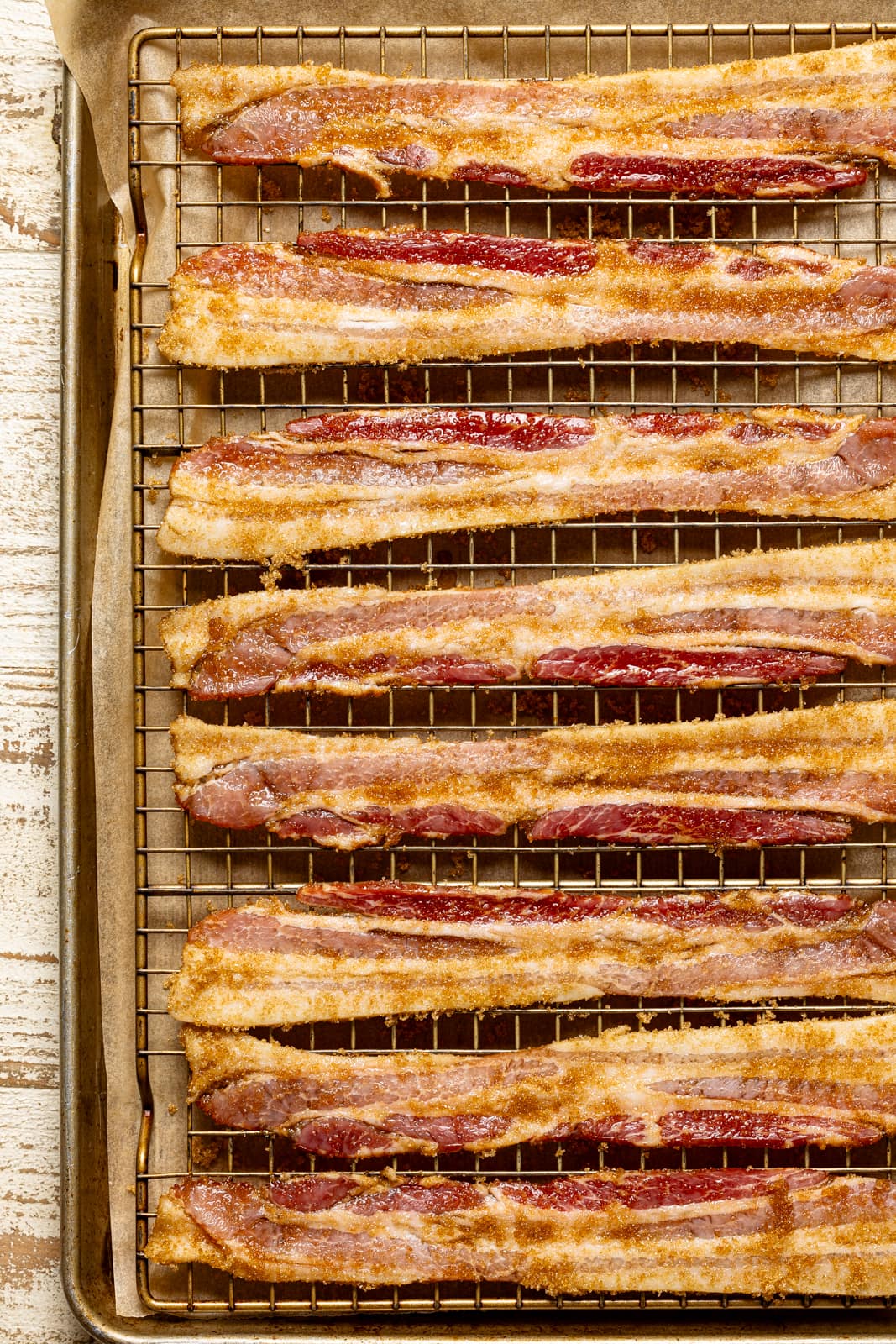 Preparing for the candied bacon recipe. Raw bacon with brown sugar topping on a baking sheet and wire rack.
