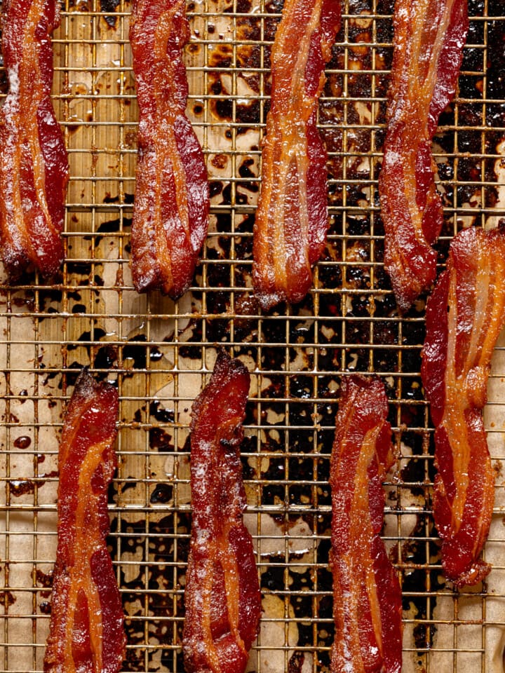 Up close shot of cooked bacon lined on a wire rack and baking sheet.