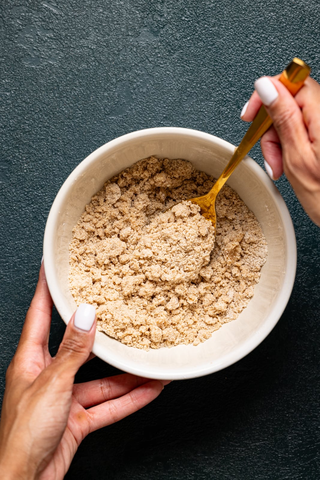 Crunch topping ingredients being stirred together in a bowl.