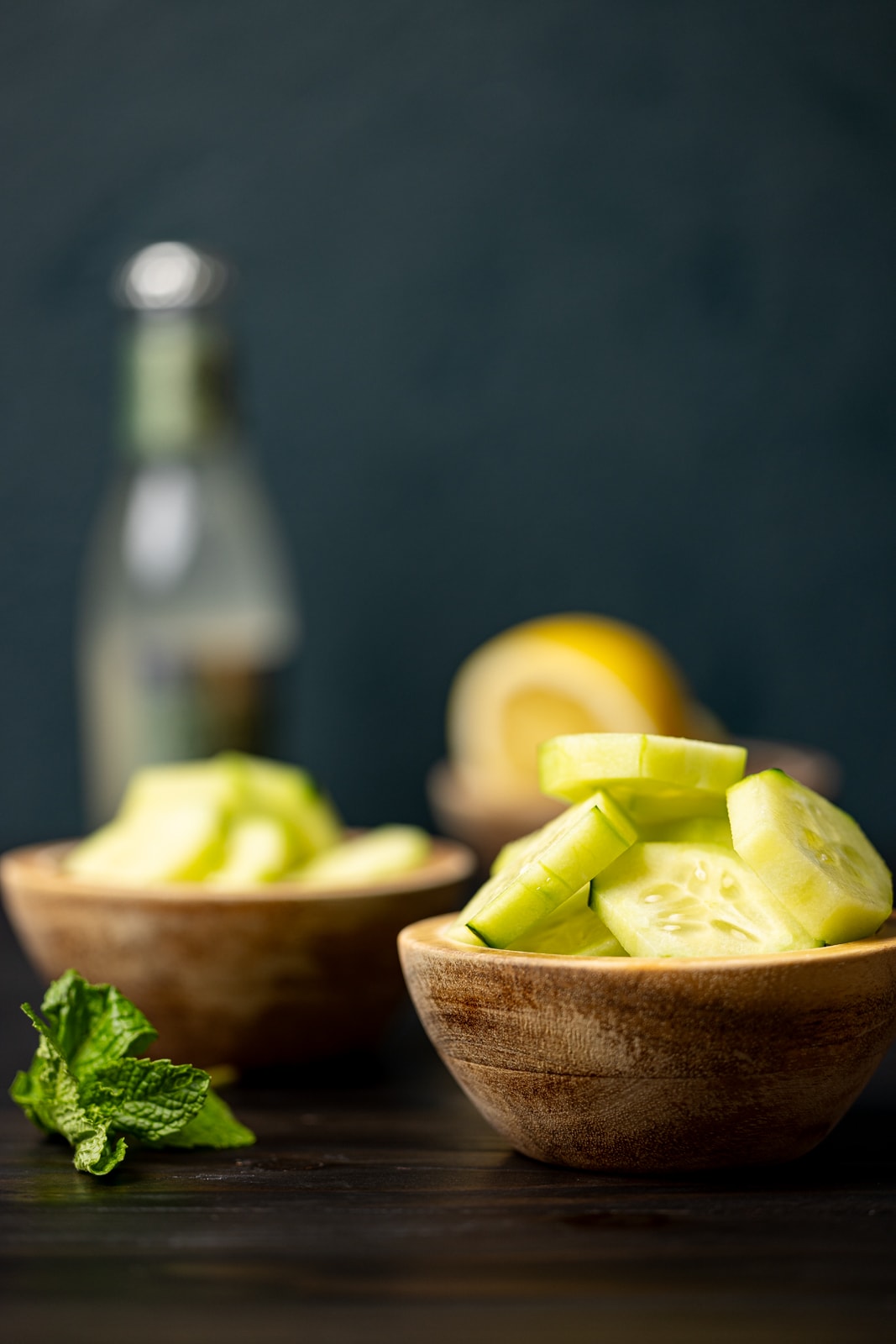 Cucumber slices in brown wood bowls for ginger mocktail recipe.