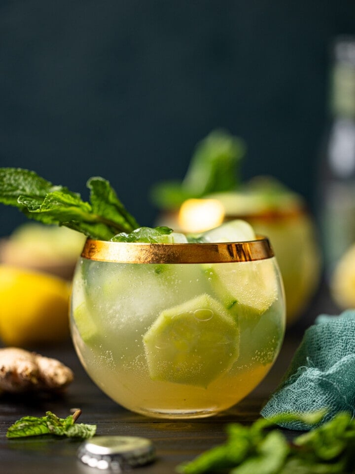 Two glasses of mocktails with lemon, ginger root, and fresh mint.