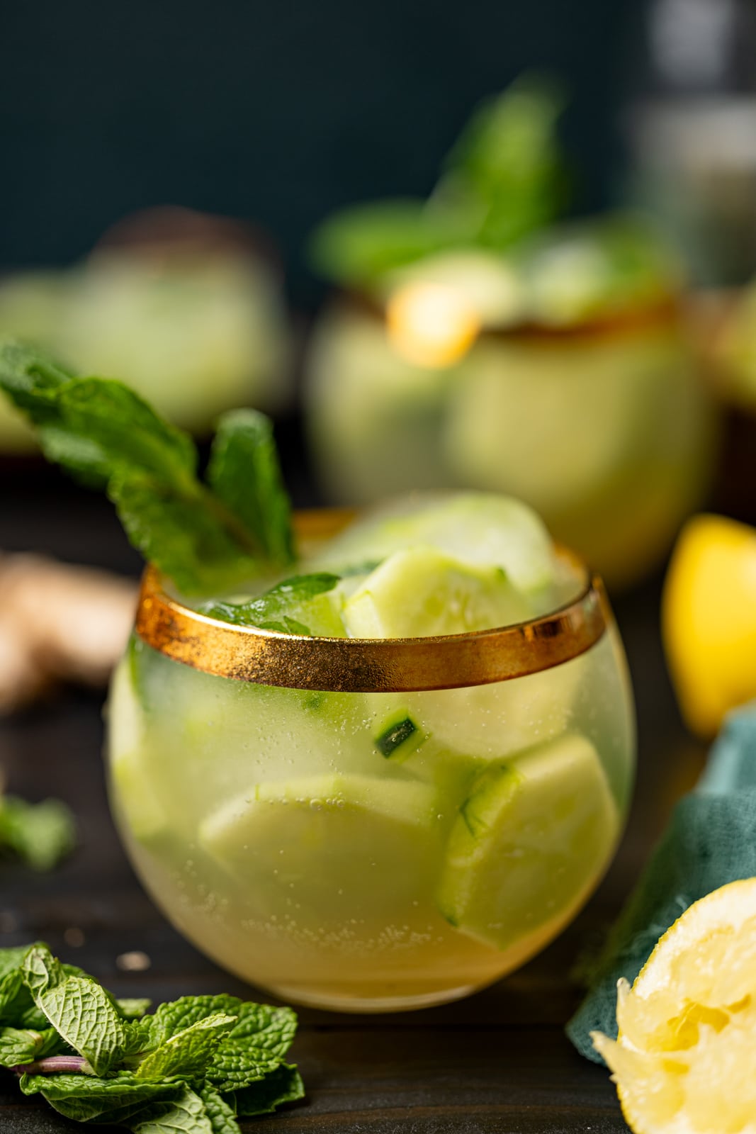 Two glasses of mocktails with lemons and herbs. 