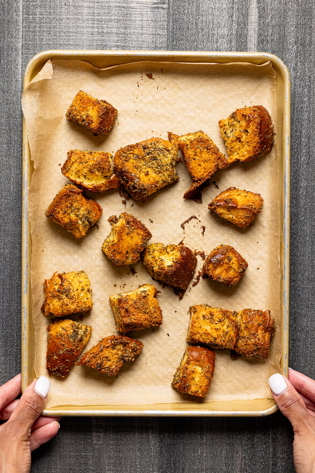 Cubed garlic bread on a baking sheet with parchment paper. 