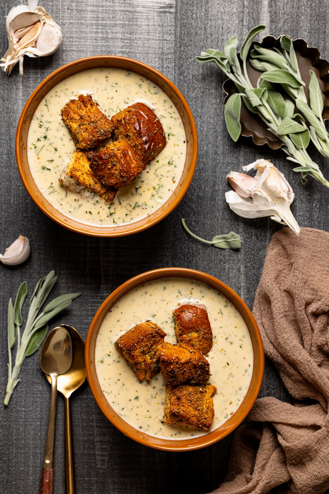 Two bowls of soup and sage leaves.