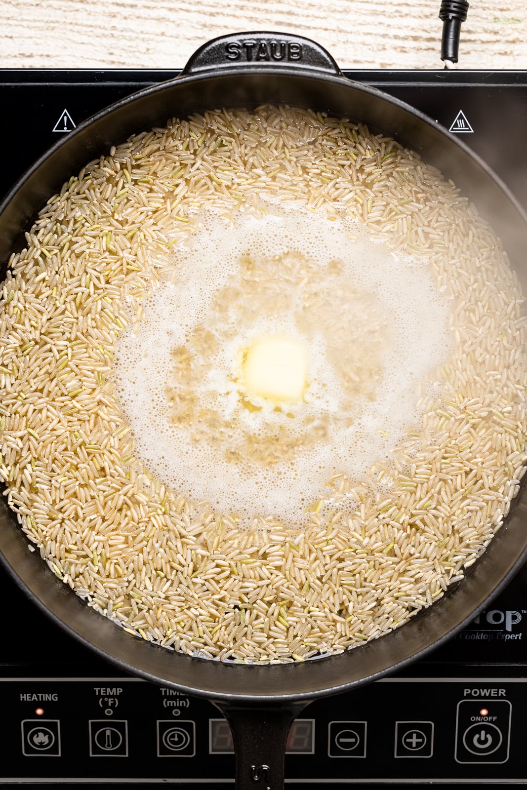 Rice being boiled on a stovetop.