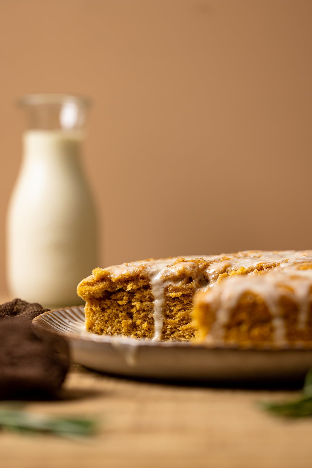 Sweet potato cake on a platter with a bottle of milk in the background. 