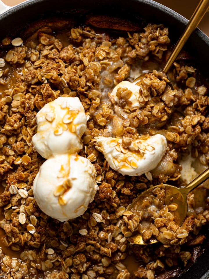 Up close shot of crisp with ice cream scoops and spoons.