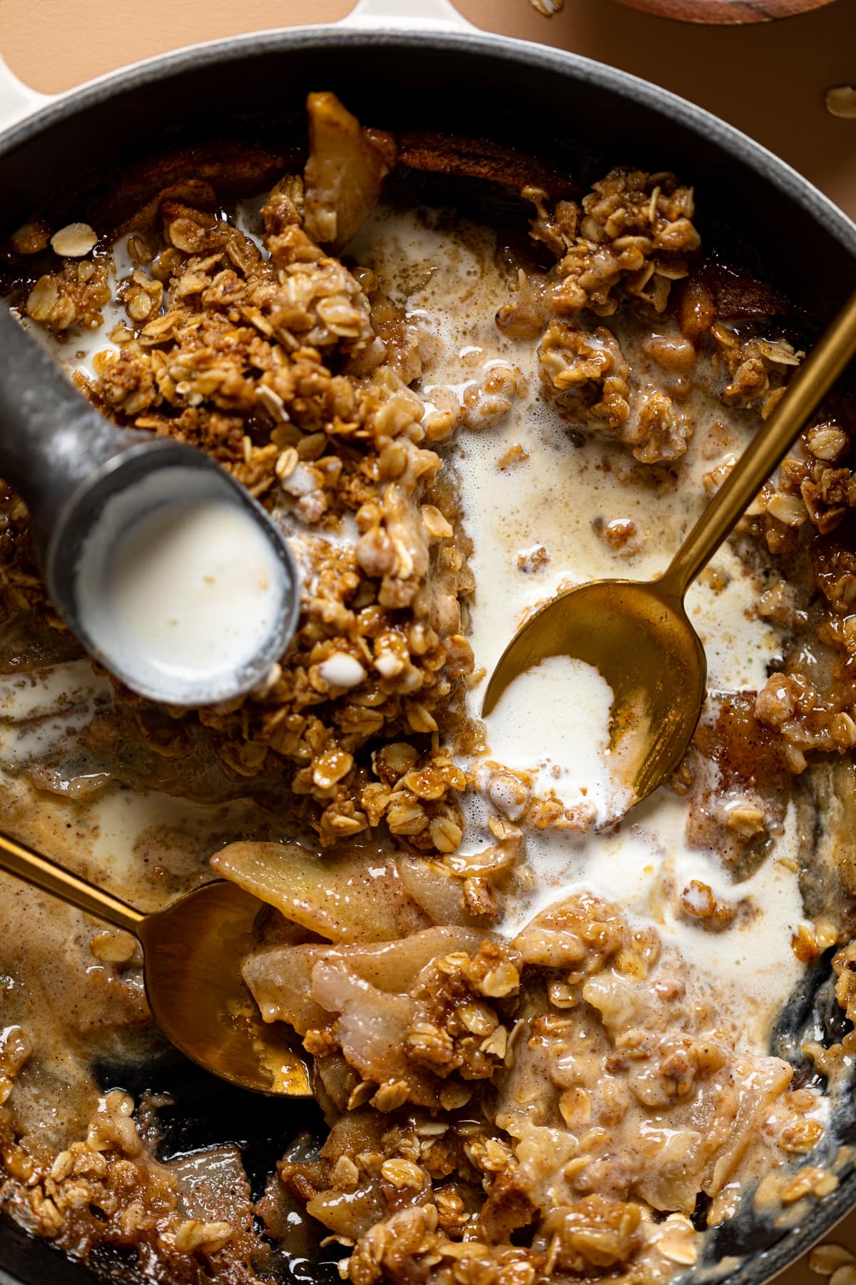 In skillet with ice cream scoops and spoons.