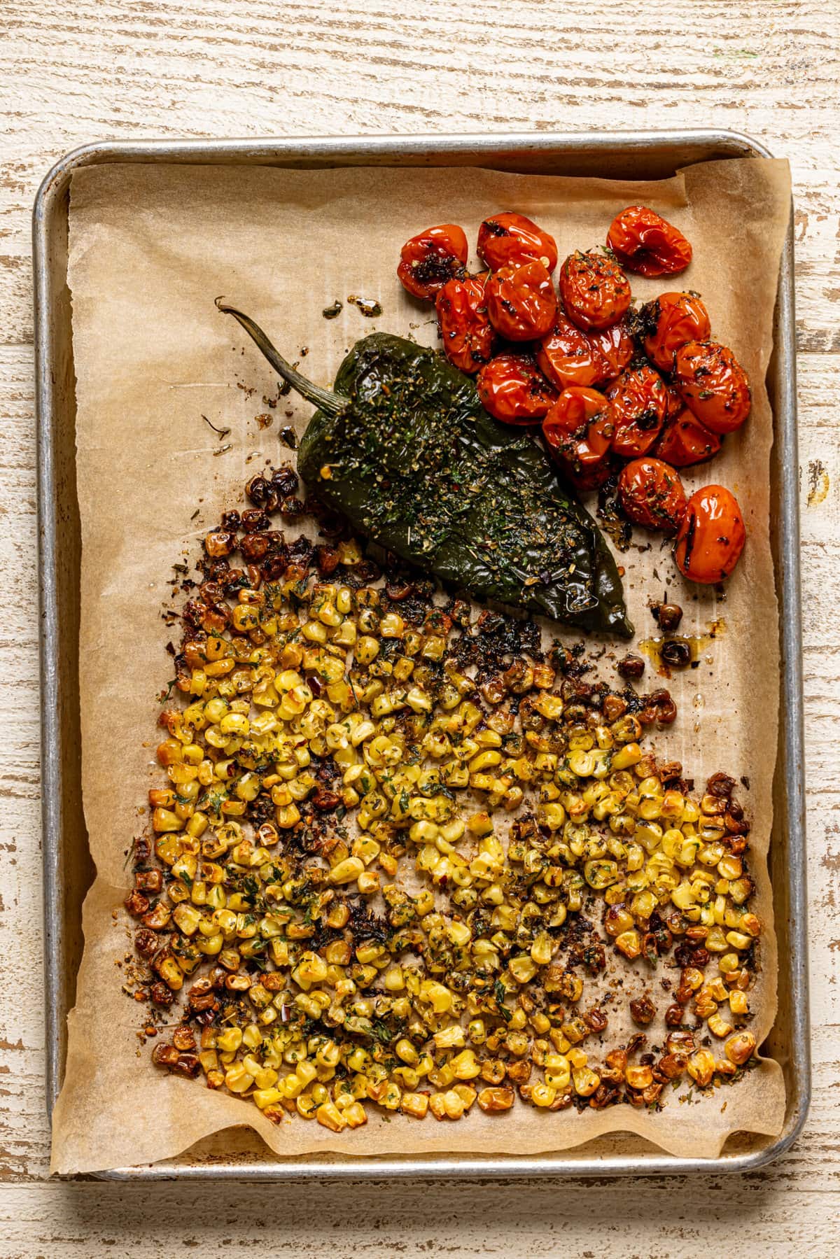 Roasted veggies on a baking sheet with parchment paper. 