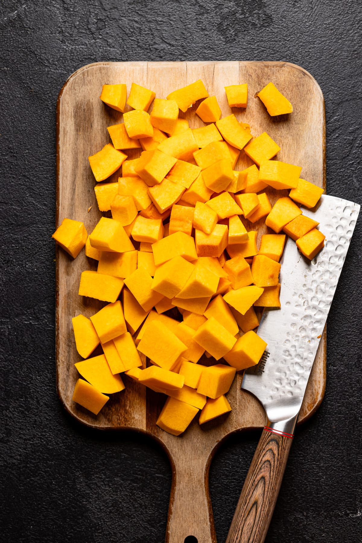 Chopped squash on a cutting board with a knife. 