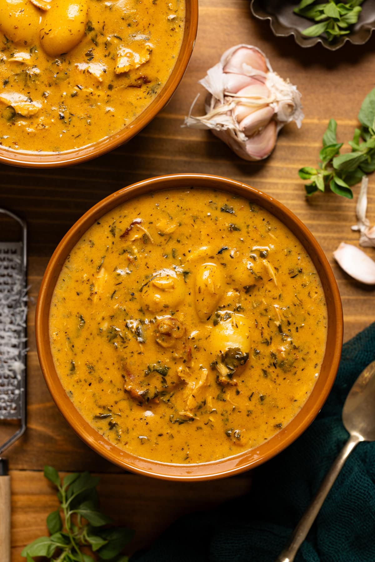 Up close shot of soup in bowl with garlic and spoon.