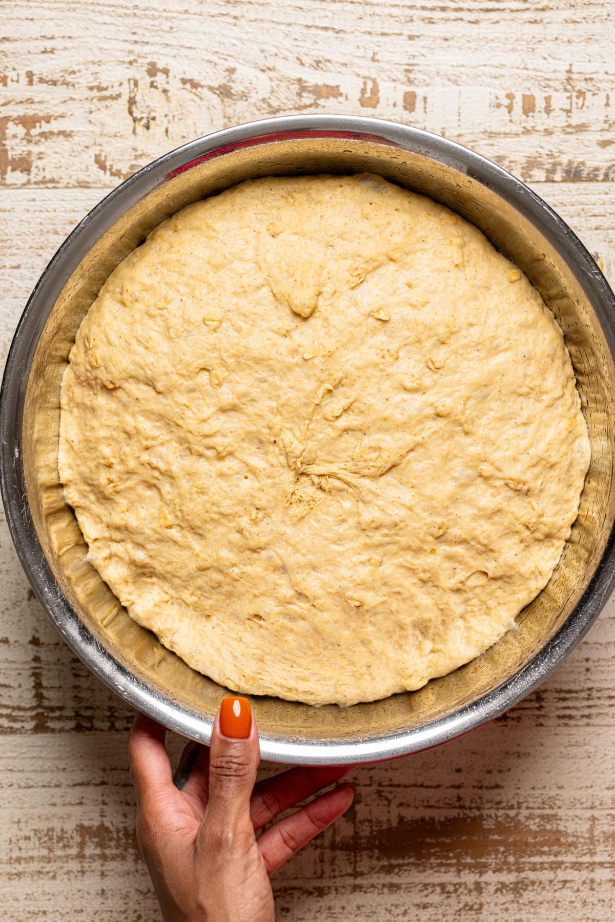 Risen dough in a silver bowl.