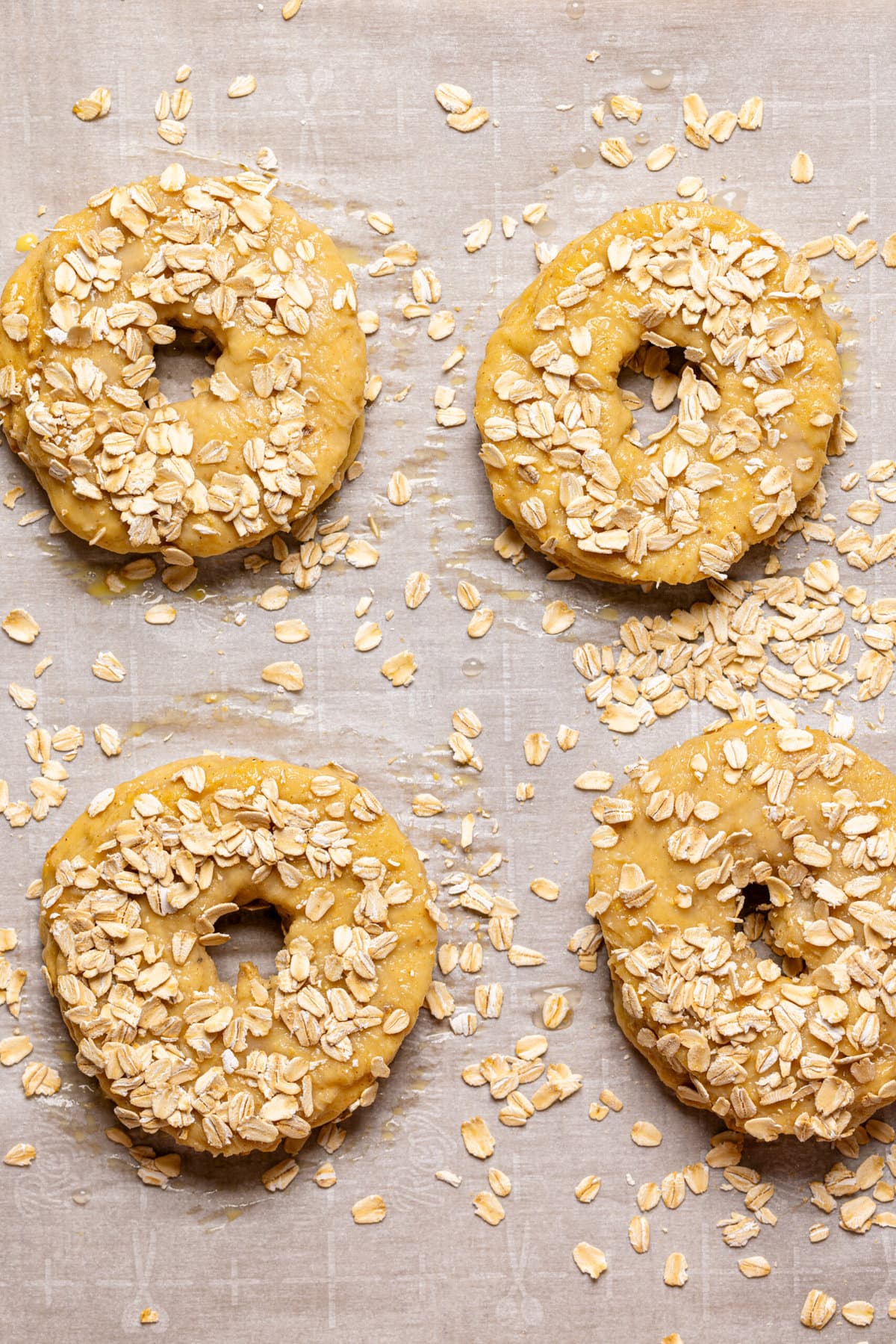 Shaped bagels on a baking sheet with parchment paper.