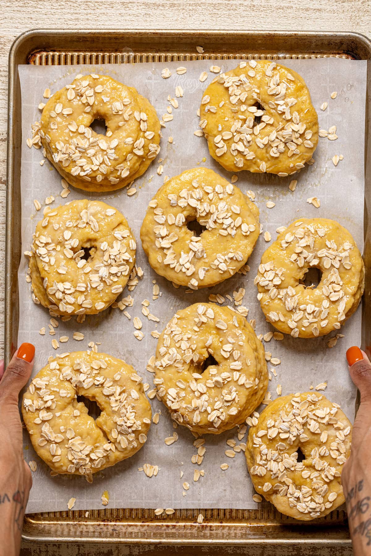 Bagels on a baking sheet with parchment paper, ready to bake.