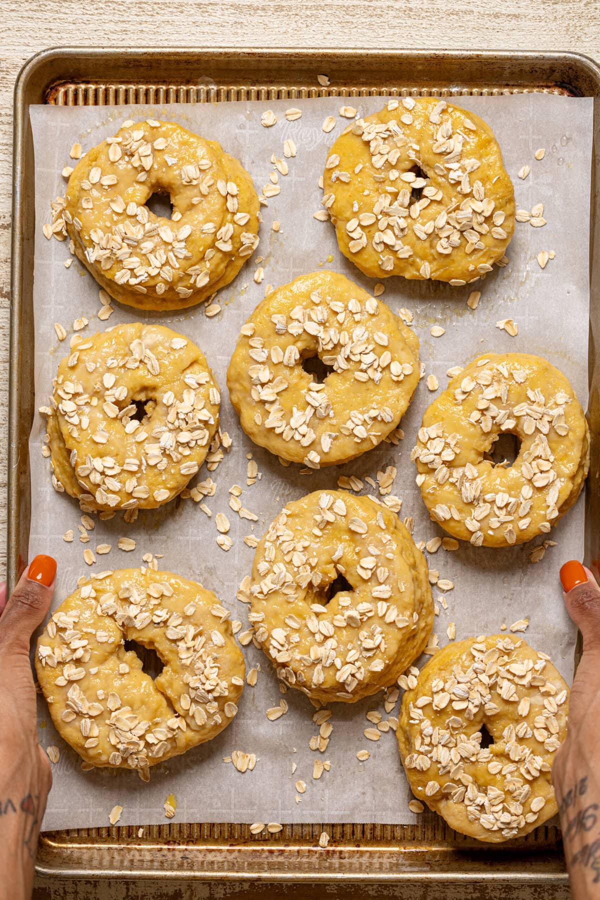 Bagels on a baking sheet with parchment paper, ready to bake.