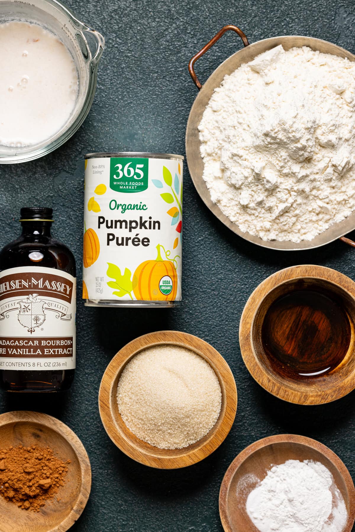 Pumpkin spice ingredients on a dark green table.