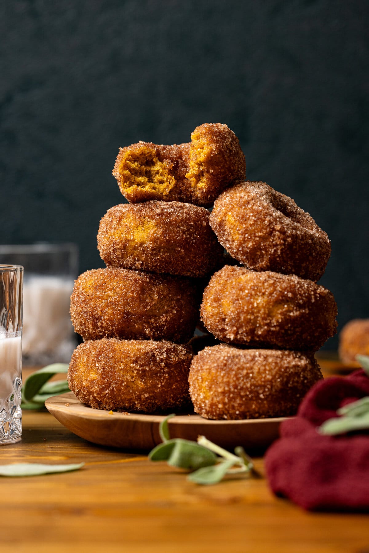 Baked donuts stacked on a brown plate.