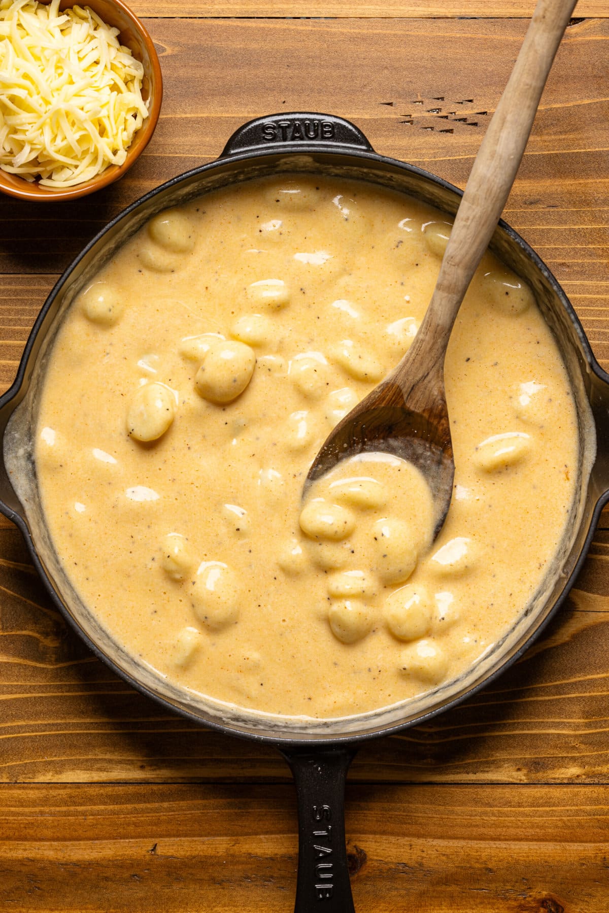 Gnocchi in cheese sauce in a black skillet.