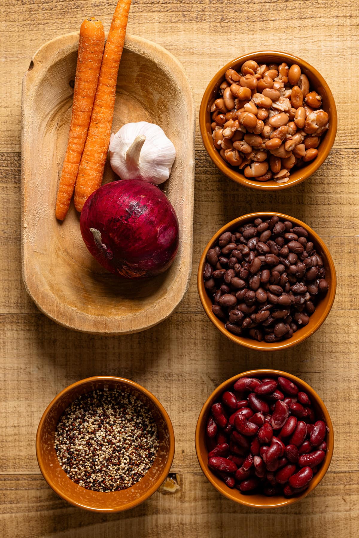 Ingredients for chili recipe on a brown wooden table.