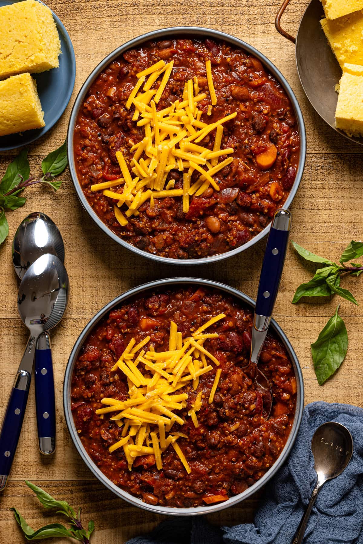 Two bowls of chili with spoons. 