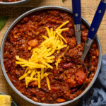 Bowl of chili with two spoons.