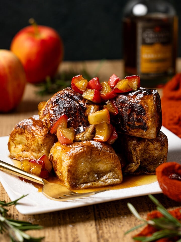 French toast on a plate with apples in the background.