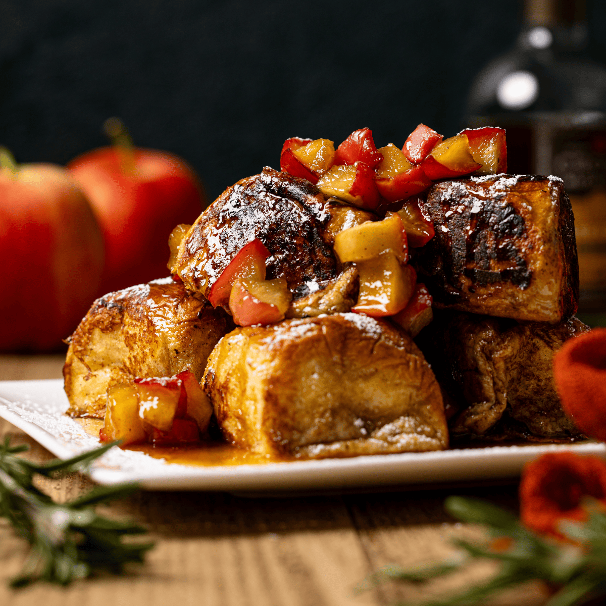 Stacked french toast with powdered sugar and apples.