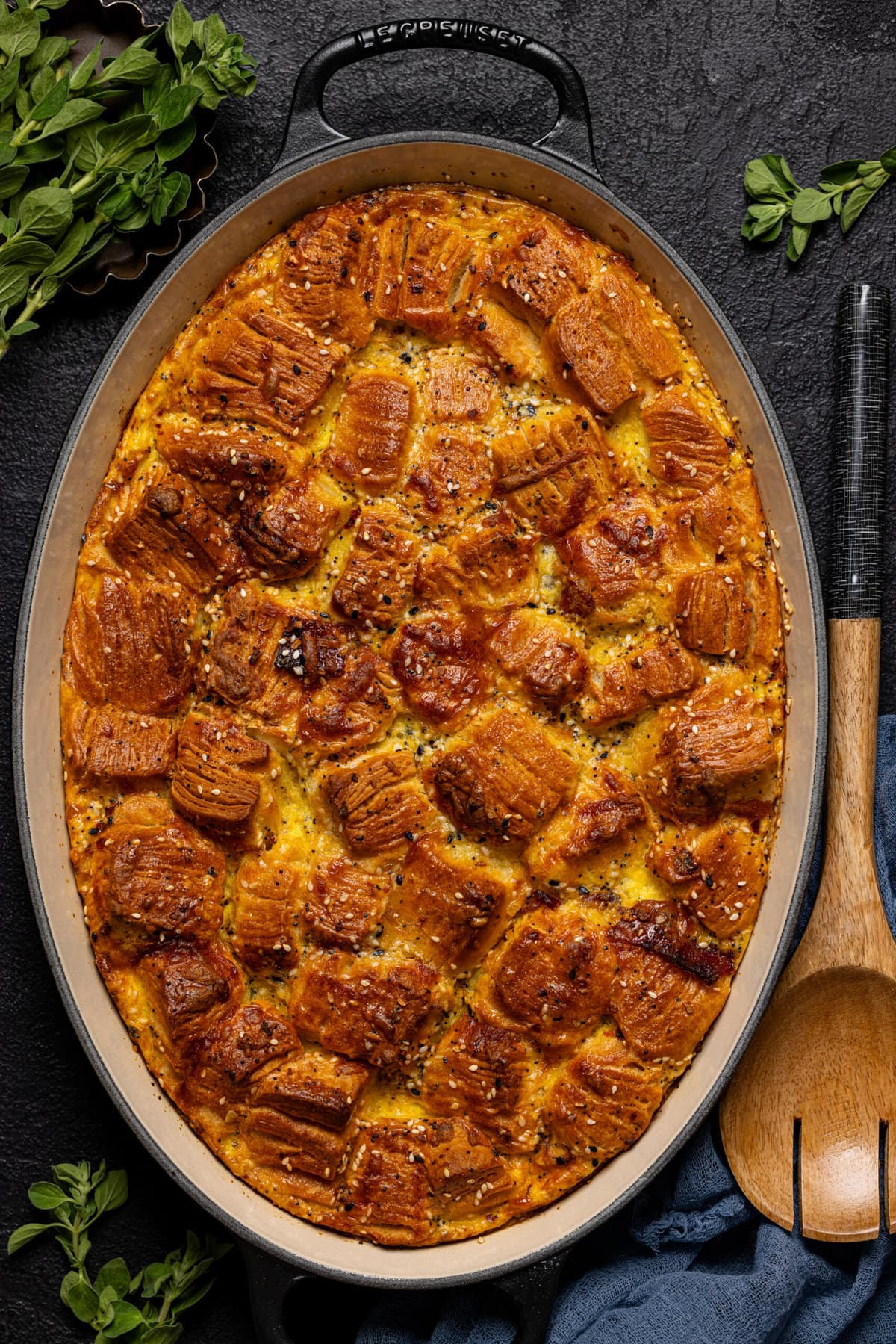 Baked casserole in a baking dish with wooden spoon.