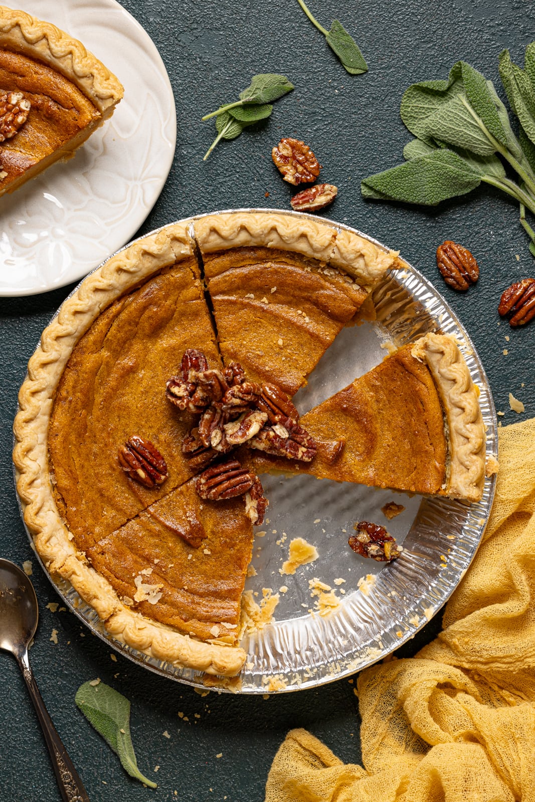 Sliced pie with a white plate of pie. 