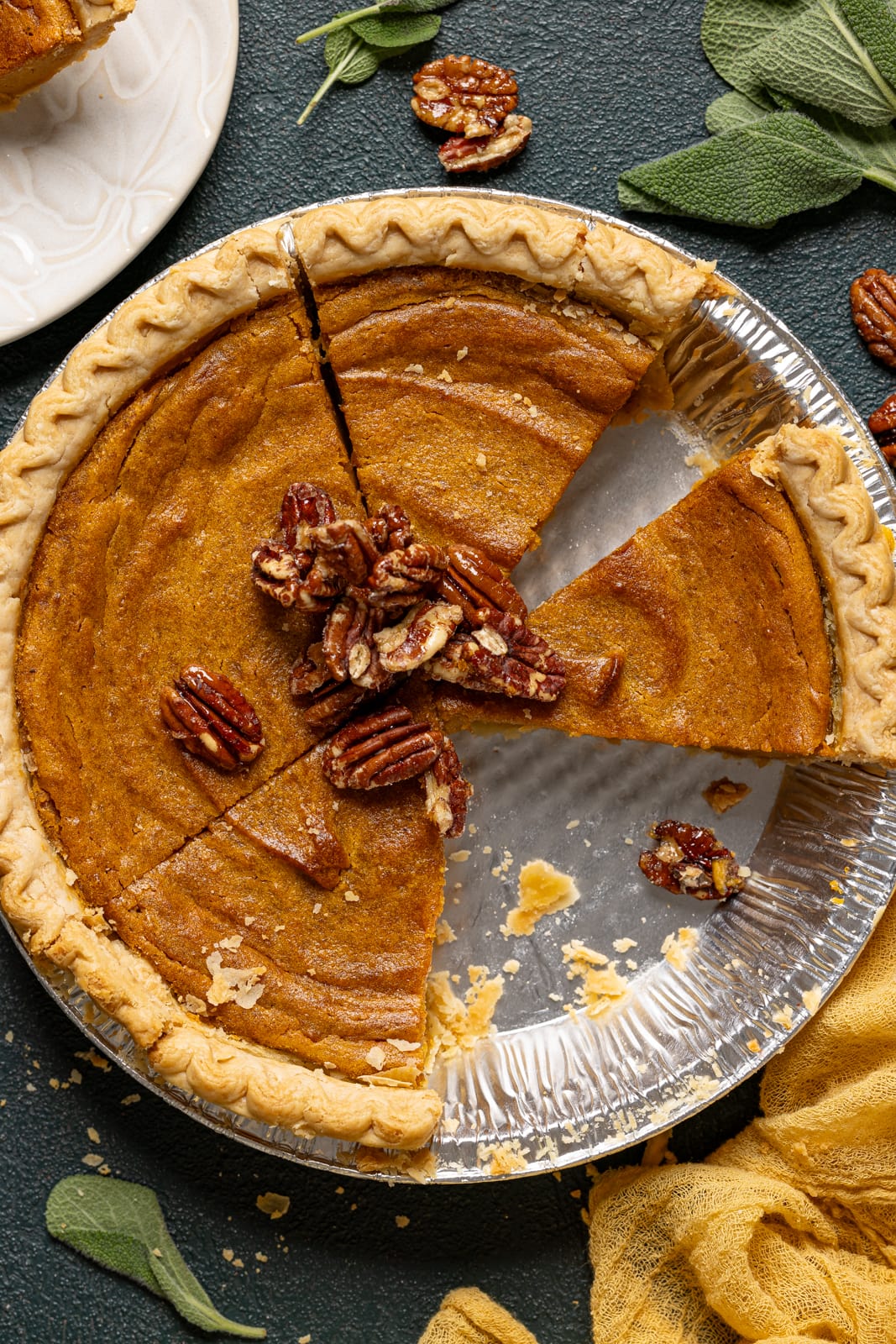 Pie in a silver tin sliced with pecans.
