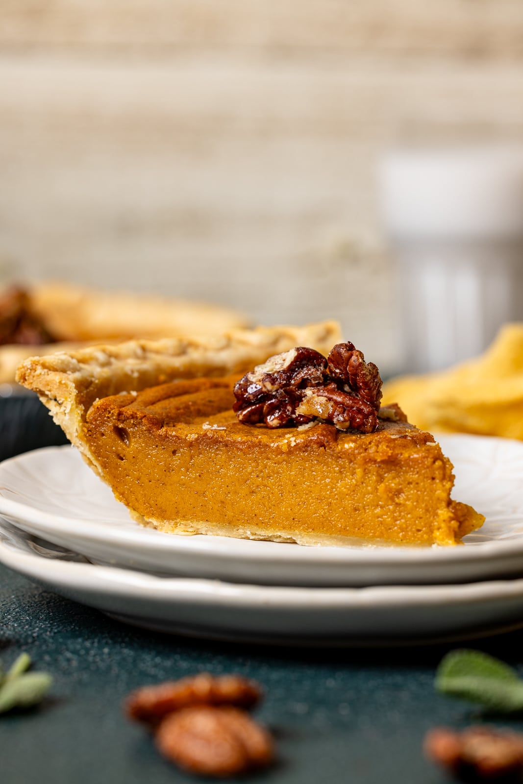 A slice of pie on two stacked white plate. 