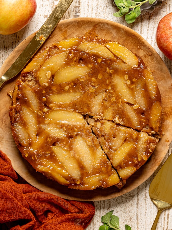Up close shot of upside down cake with knife + spatula.