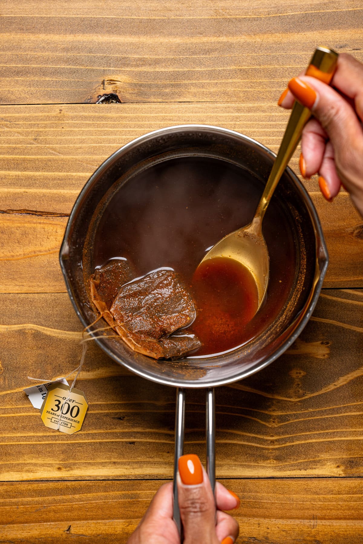 Chai tea mixture in a saucepan with tea bags.