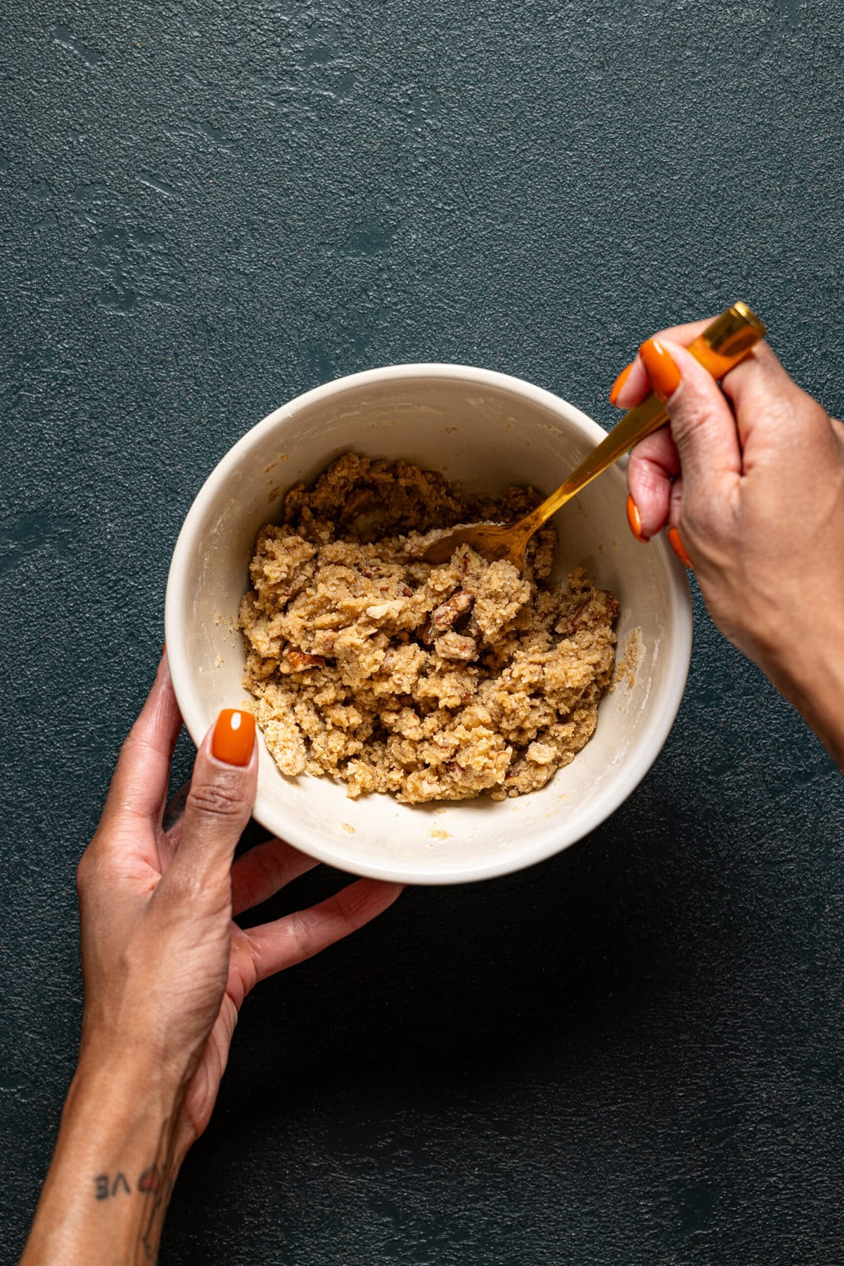 Crumble topping being mixed together in a bowl with a spoon.