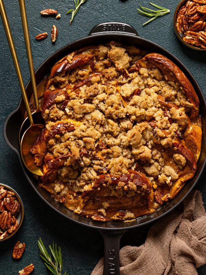 Baked casserole in a skillet with two spoons.