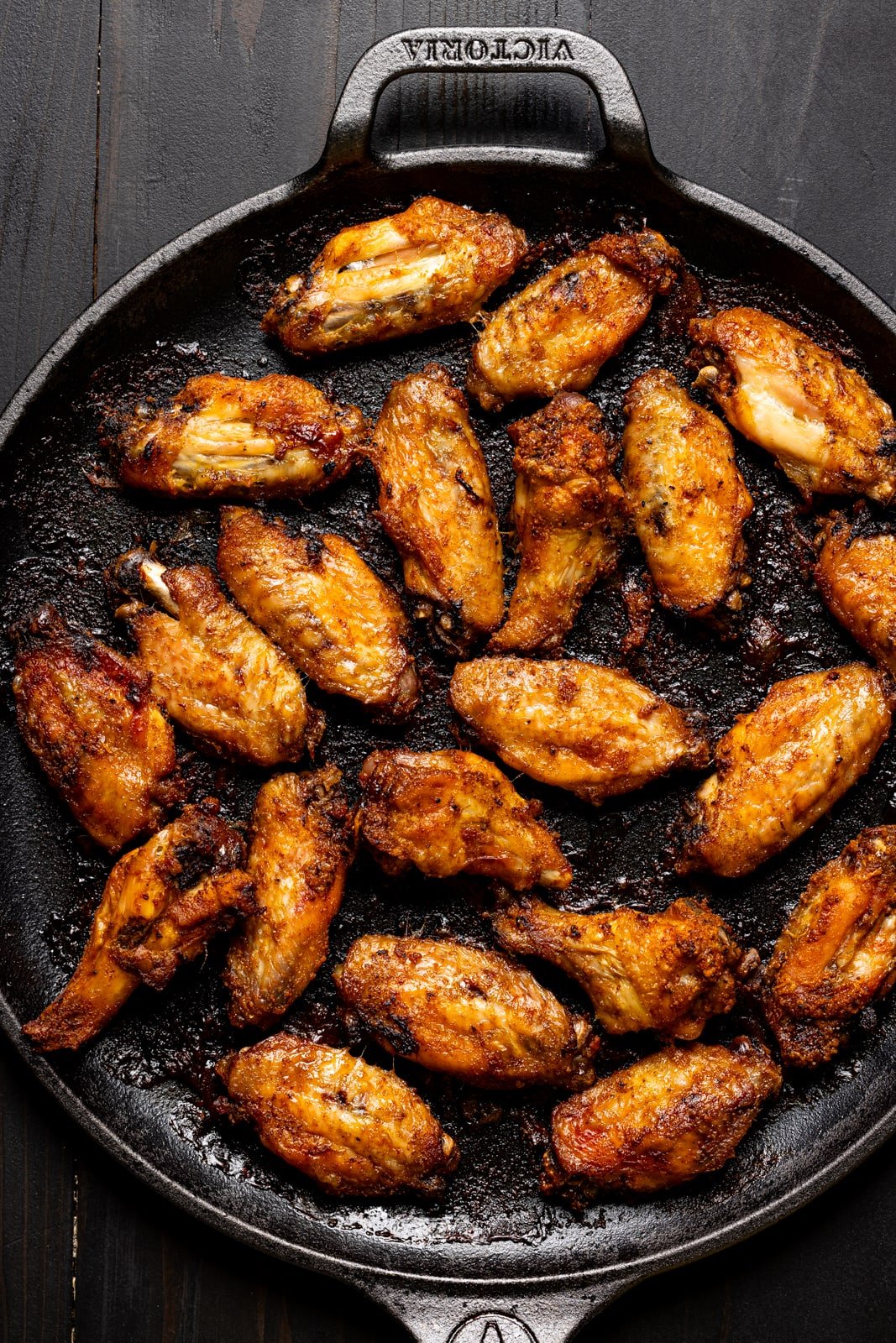 Baked wings on a black skillet.