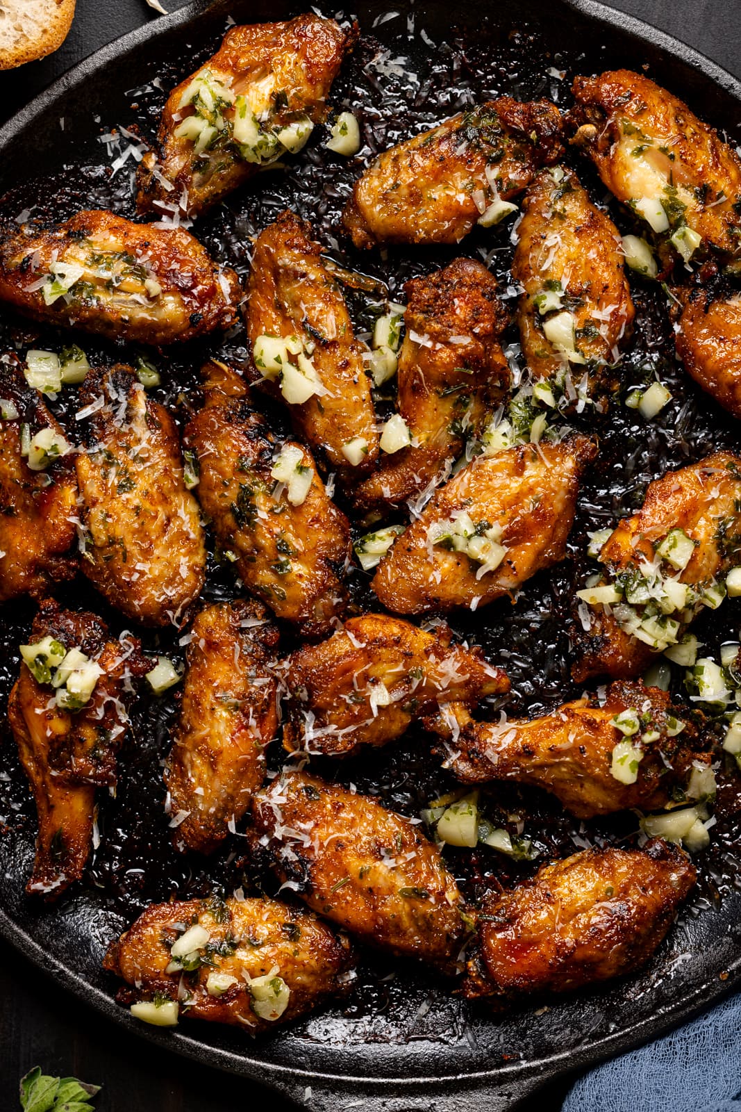 Up close shot of chicken wings with green garnish.