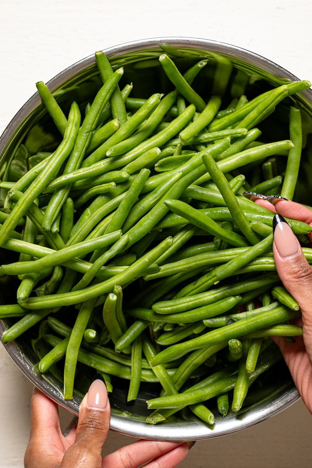 Green beans in a silver bowl.