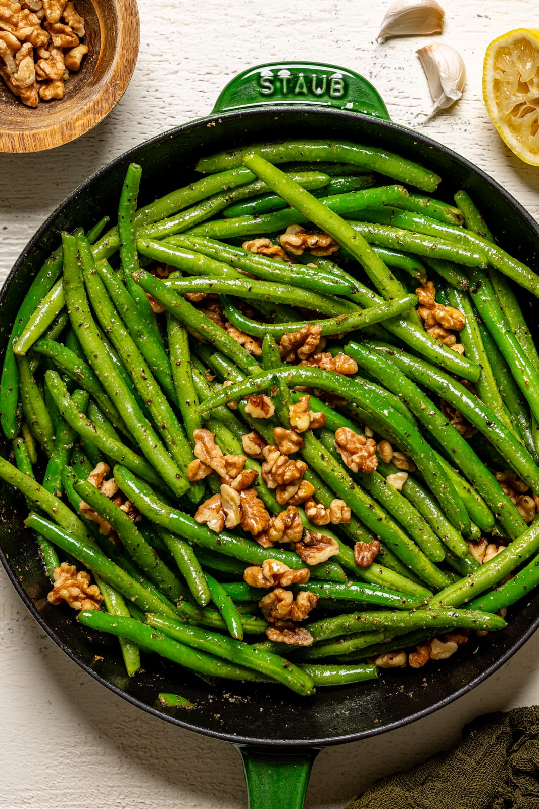 Sautéed green beans in a green skillet. 