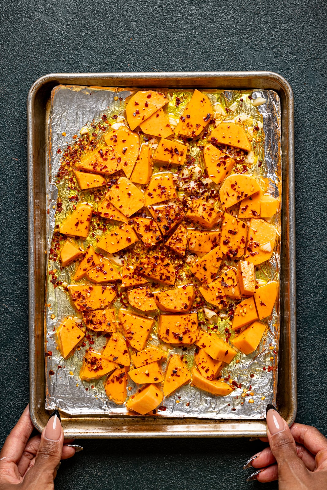 Roasted sweet potatoes on a baking sheet with foil paper.