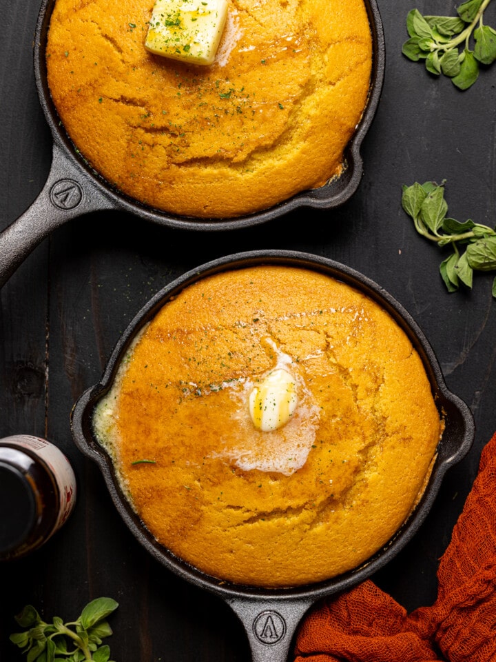 Up close shot of cornbread in a mini skillet with butter.